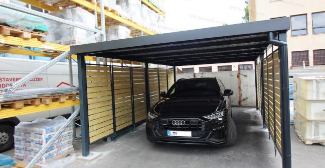 Ein Audi geparkt unter dem Carport von GARDEON in anthrazit mit Holzlatten