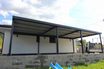 Ein montiertes Doppelcarport von GARDEON mit DRIPSTOP bei einem Familienhaus