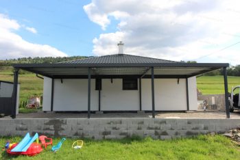 Ein großes Carport von GARDEON neben einem Familienhaus