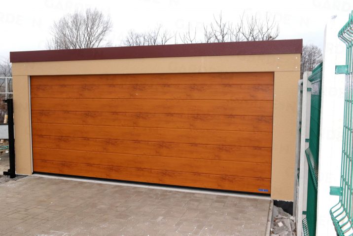 Eine Doppelgarage mit dem Tor in der Farbe goldene Eiche