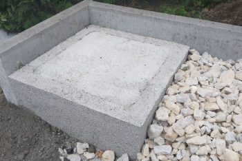 Fußpunkt aus Beton in einer Straßenschotter-Schicht