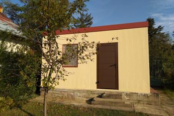 Fertige GARDEON Gartenhütte in einem Garten