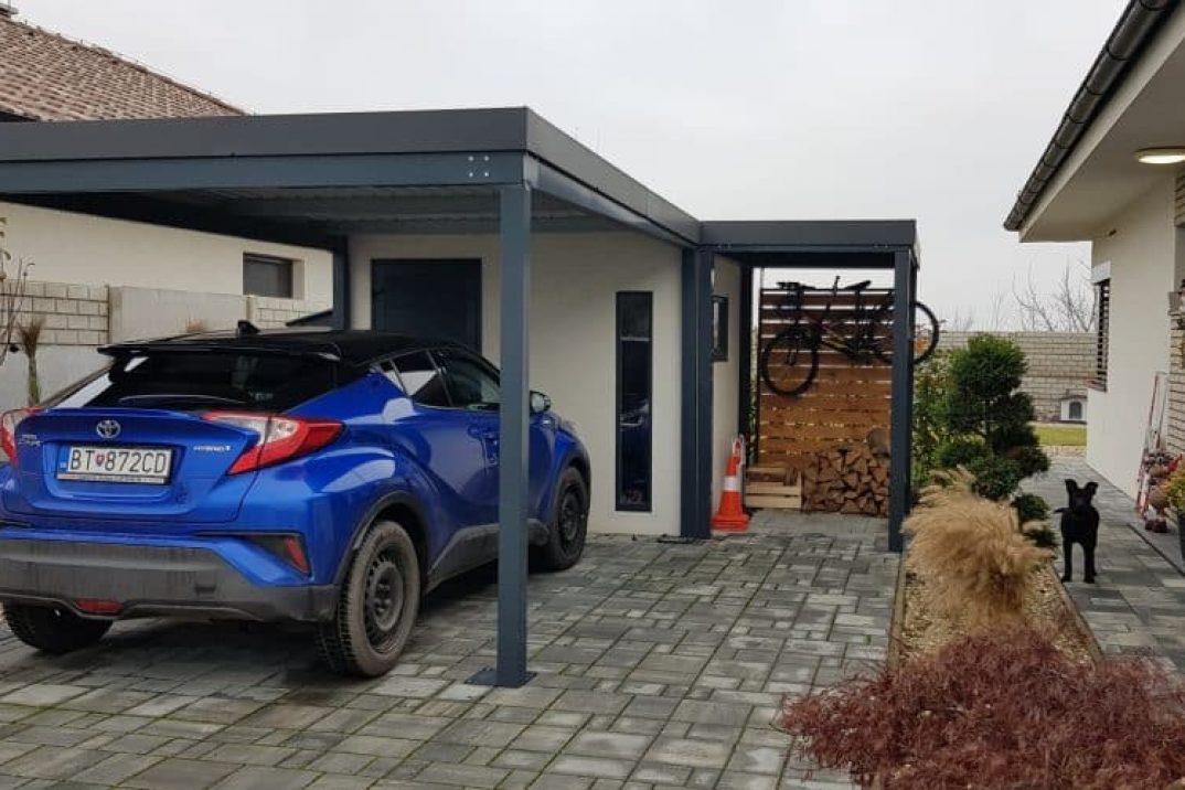 Auto geparkt unter einer Überdachung neben einer Gartenhütte