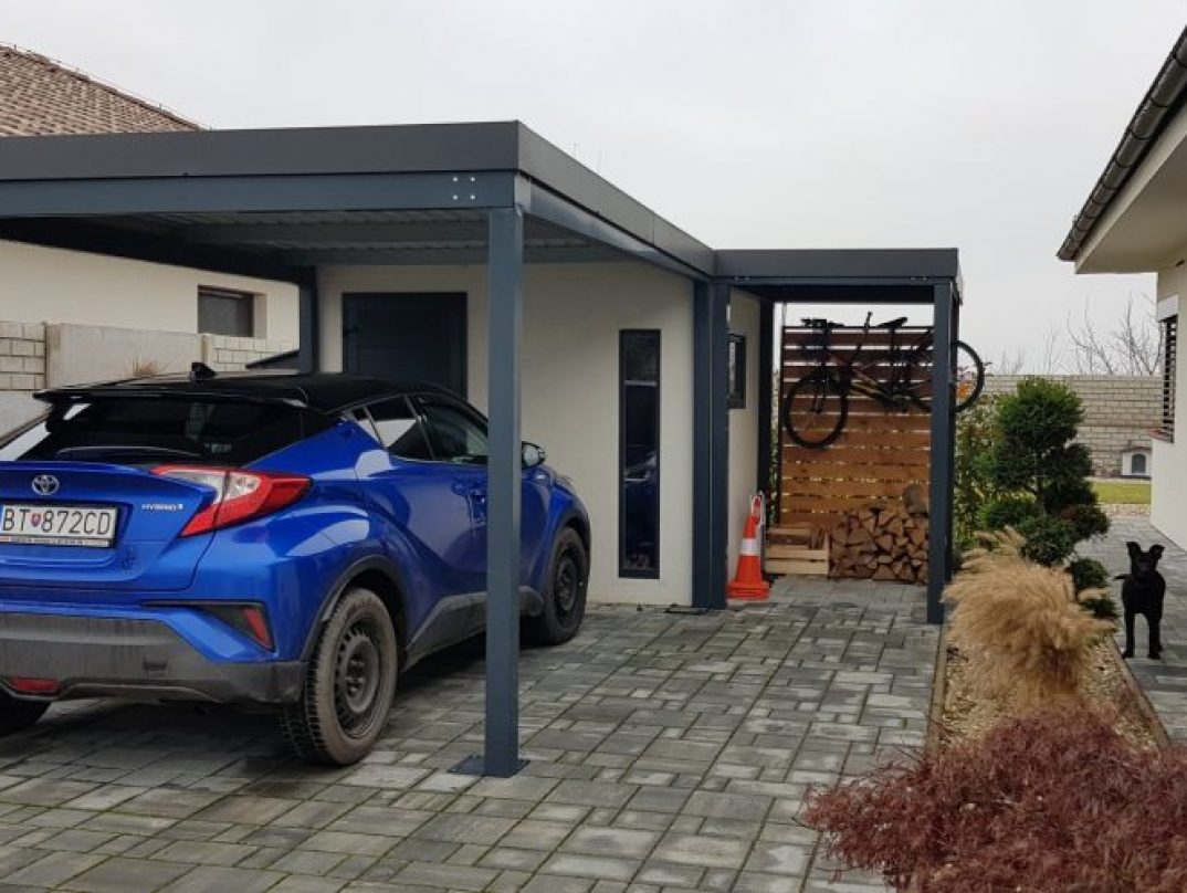 Auto geparkt unter einer Überdachung neben einer Gartenhütte