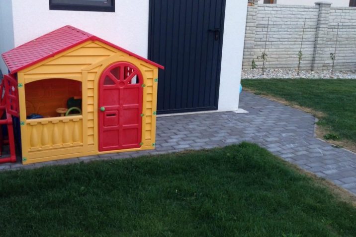 Eine kleine Gartenhütte aus Kunststoff neben dem Gartenhaus GARDEON