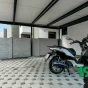 Ein Motorrad geparkt unter einem GARDEON Stahlcarport mit Dachdämmung