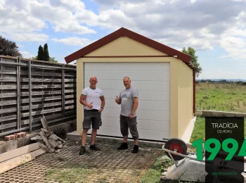 Zufriedener Kunde aus Österreich mit einem der GARDEON Monteure vor seiner neuen Garage mit Satteldach
