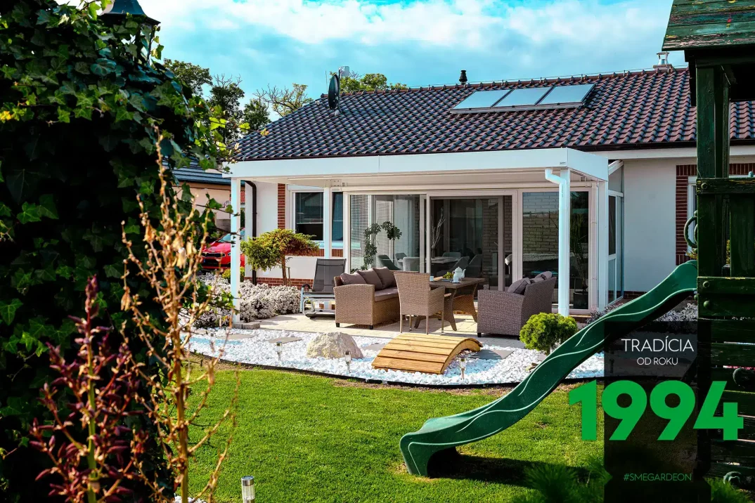 Weiße GARDEON Gartenpergola mit Pultdach neben einem Haus mit Satteldach