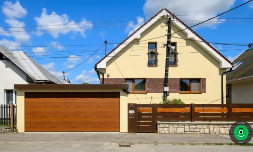 Ein Fertiggarage mit gelbem Putz und breitem braunem Garagentor.