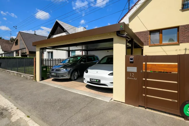 Kombination aus gelbem Putz und braunem Tor für einen modernen Carport.