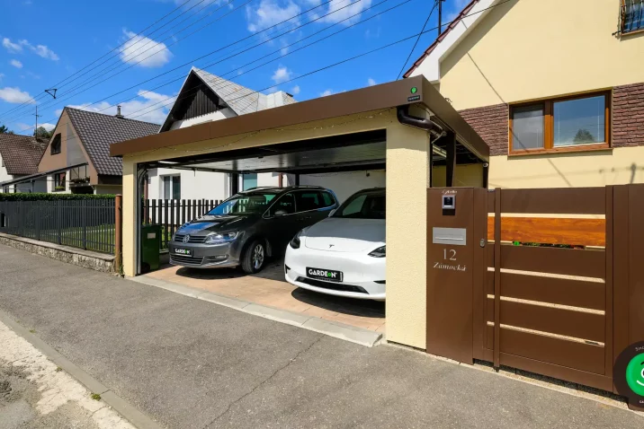 Kombination aus gelbem Putz und braunem Tor für einen modernen Carport.