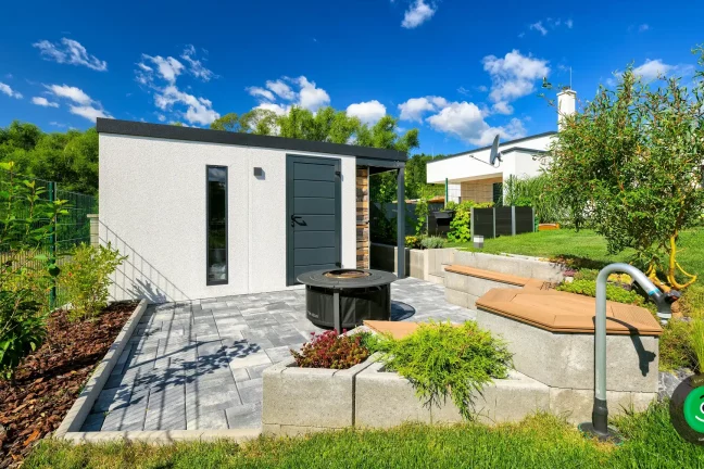 Kleines Gartenhaus mit Lagerplatz für Holz und einem Platz im Freien zum Entspannen.