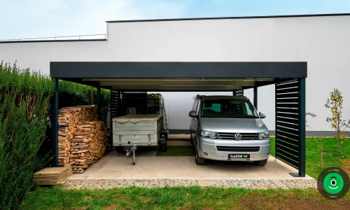 Auto unter dem Carport geparkt, der auch als Holzlager genutzt wird