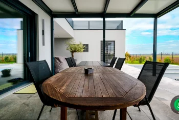 Tisch und Stühle als Sitzgelegenheiten unter Überdachung