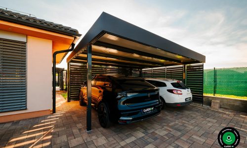 Überdachter Unterstand am Haus mit zwei geparkten Autos