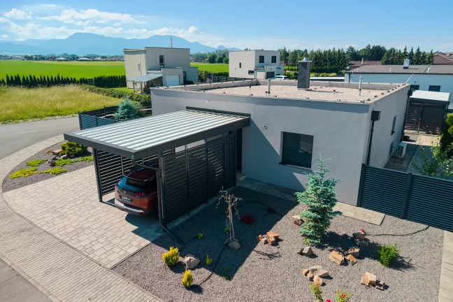 Anthrazitfarbenes Vordach mit Metallfüllung und Trapezblech am Einfamilienhaus.
