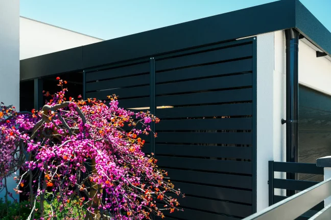 Seitendetail der modernen Carportkonstruktion mit anthrazitfarbenem Sichtschutz