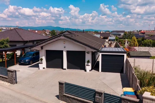 Garage für ein Auto mit anthrazitfarbenem Pultdach und dunklem Sektionaltor, Frontansicht