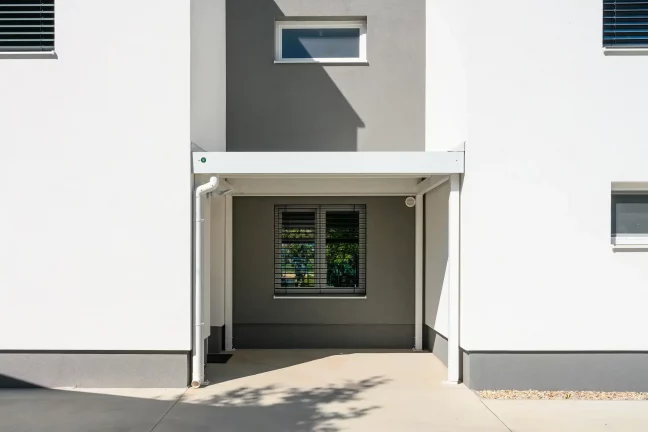 Praktische Überdachung beim Gartenhaus mit klarem modernem Design