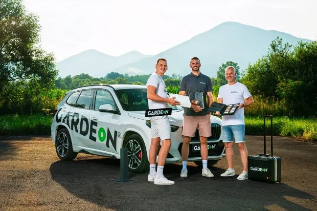 Drei GARDEON-Agenten mit Materialien und Koffer am Firmen-BMW.