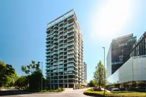Modernes Hochhaus mit verglasten Balkonen und wei&szlig;er Fassadenkonstruktion