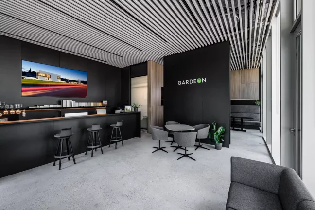 Moderner GARDEON Showroom mit schwarzer Wand, Bartheke und Lamellendecke
