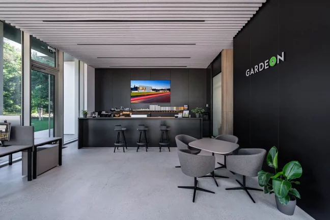 Verglaste Showroom-Wand lässt Tageslicht vom grünen Garten hereinfluten