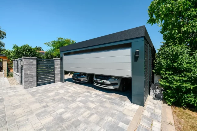 Zwei Autos unter dem Carport mit Tor geparkt