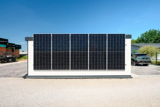 Detailansicht von fünf Solarmodulen an der weißen Gebäudewand