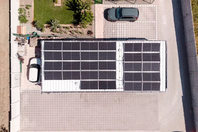 Luftaufnahme von oben mit Blick auf die Solarmodule auf dem Dach und die Autos