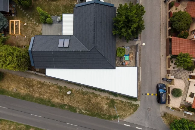 Luftaufnahme von oben mit Blick auf das weiße Pultdach der Garage neben dem Haus
