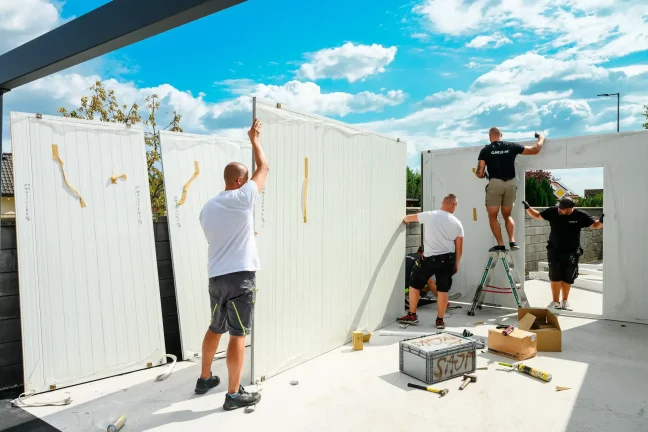 Monteure bringen weiße Wandpaneele an der Garage an