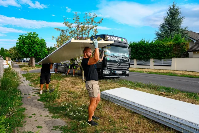 Mitarbeiter lädt ein verpacktes Wandpaneel aus einem GARDEON-Lkw aus