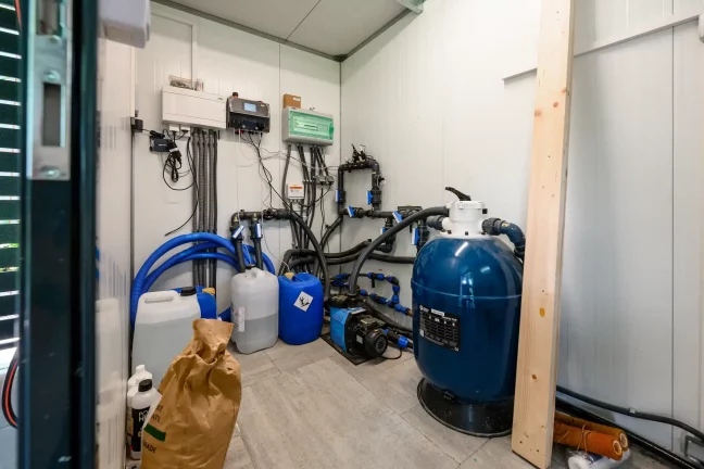 Technikraum mit Poolfilter und Chemikalien
