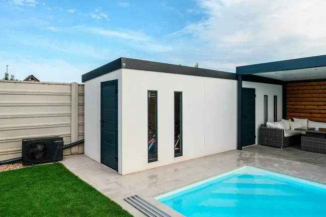 Weißes Gartenhaus mit dunklen Türen und Fenstern sowie Fahrrädern im Inneren