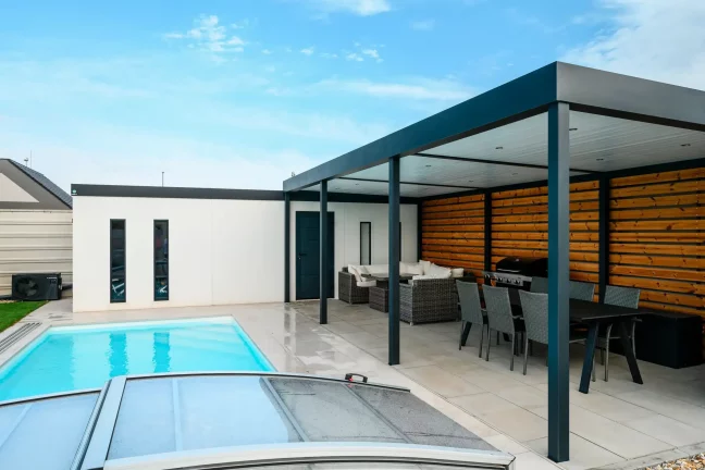 Seitenwand des Gartenhauses mit Klimaanlage neben dem Pool und der Pergola