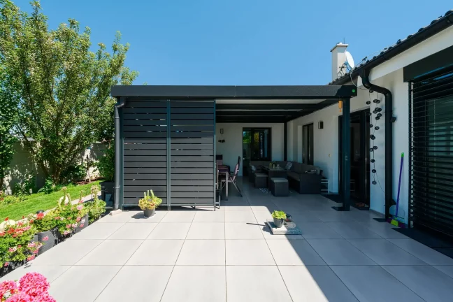 Sofa und Esstisch unter der Pergola am Haus