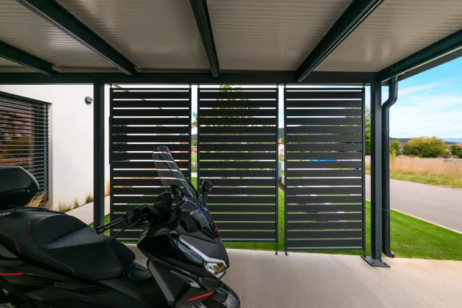 Motorrad unter dem Carport an der Lamellenwand
