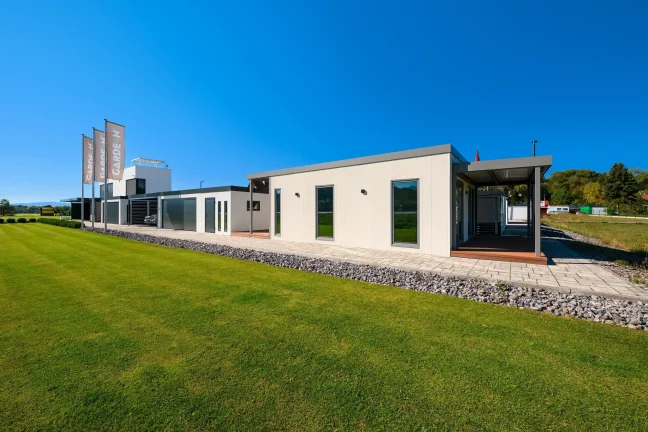 Tiny House im GARDEON-Showroom aus der Ferne mit Fenstern an der Seitenwand neben dem Rasen