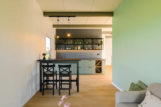 Blick in die Küche des Tiny Houses mit Bartisch und offenen Regalen