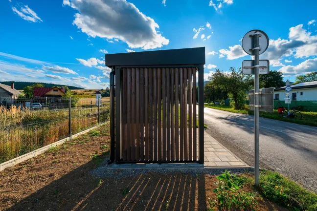 Haltestellenüberdachung von der Seite mit Verkehrsschild an der Straße